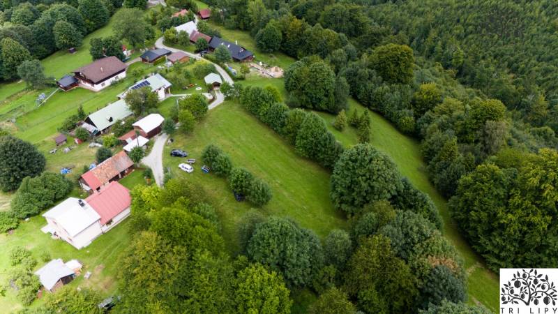 Luftaufnahme von Erholungsgrundstücken in Oščadnica, umgeben von Wäldern und Häusern.