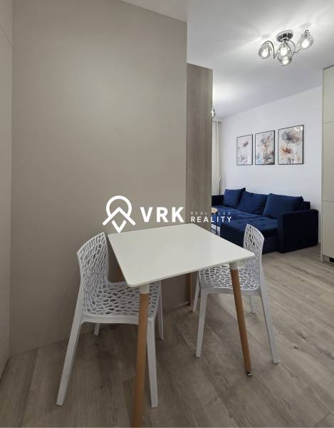 Essbereich mit Tisch und Stühlen in einer 2-Zimmer-Wohnung, weißes Interieur.