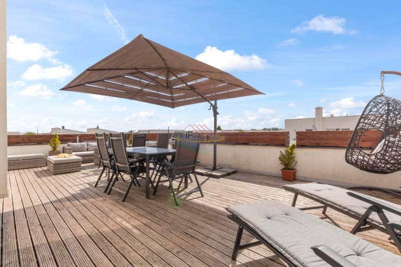 Terrasse einer 4-Zimmer-Wohnung in der Pivonkova-Straße in Rovinka mit Außenbereich und Liegestühlen.