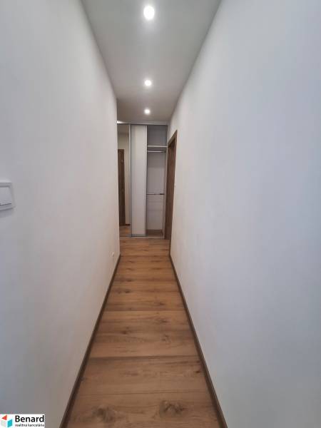 Ein enger Flur mit Holzboden und einem Einbauschrank in einer 2-Zimmer-Wohnung.