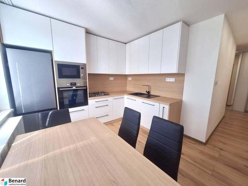 Küche in einer 2-Zimmer-Wohnung mit modernen Möbeln, Geräten und einem Esstisch.