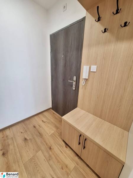 Eingangsflur mit Eingangstür und Holzmöbeln in einer 2-Zimmer-Wohnung.