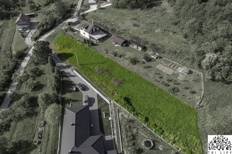 Luftaufnahme von Baugrundstücken in Raková, umgeben von Grünflächen und Häusern.