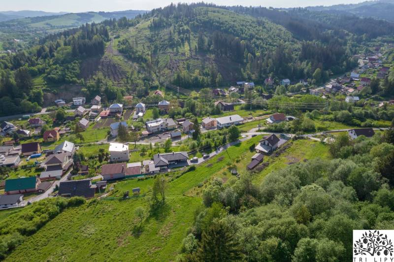 Luftaufnahme von Wohngebieten in Rakov umgeben von Grünflächen und Hügeln.