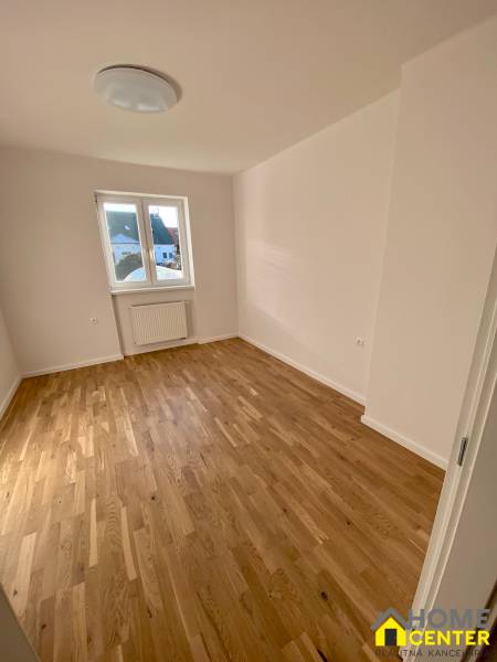 Ein Zimmer in einer 3-Zimmer-Wohnung mit Holzboden und einem großen Fenster.