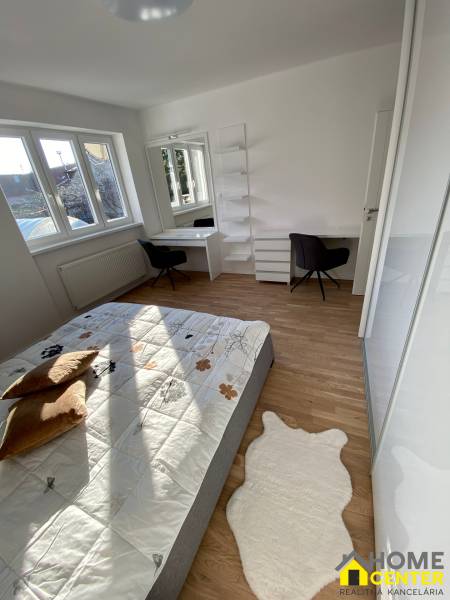 Schlafzimmer in einer 3-Zimmer-Wohnung mit Bett, Schreibtisch und Regalen, helle Holzböden.