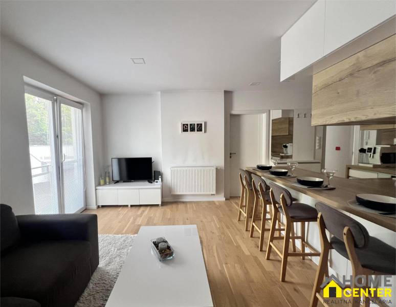 Wohnzimmer in einer 3-Zimmer-Wohnung mit Esstheke und Zugang zur Terrasse.