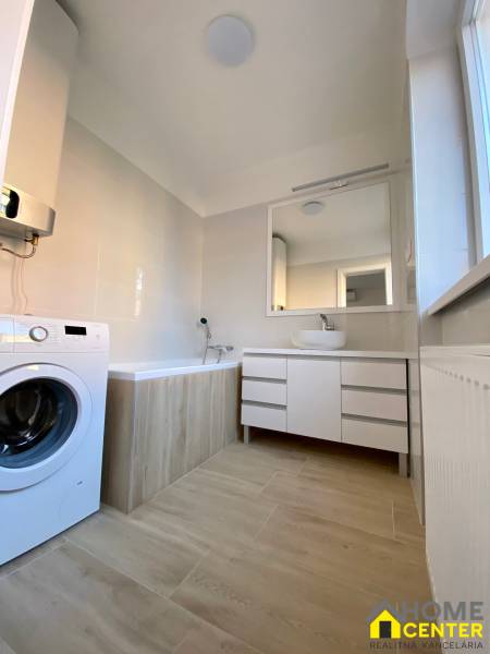 Badezimmer in einer 3-Zimmer-Wohnung mit Badewanne, Waschmaschine und Spiegelschrank.
