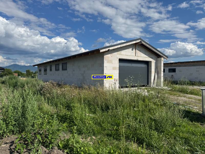 Unvollendetes Einfamilienhaus in Valča, umgeben von üppiger Vegetation und Bergkulisse.