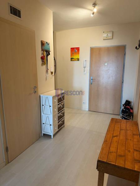 Eingangsbereich mit Schrank und Holztisch in einer 2-Zimmer-Wohnung.