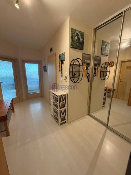 Der Flur in einer 2-Zimmer-Wohnung mit weißen Möbeln und einem Spiegelschrank.