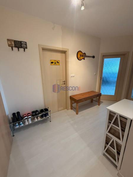 Der Flur einer 2-Zimmer-Wohnung mit Schuhschrank, Bank und Wanddekoration.