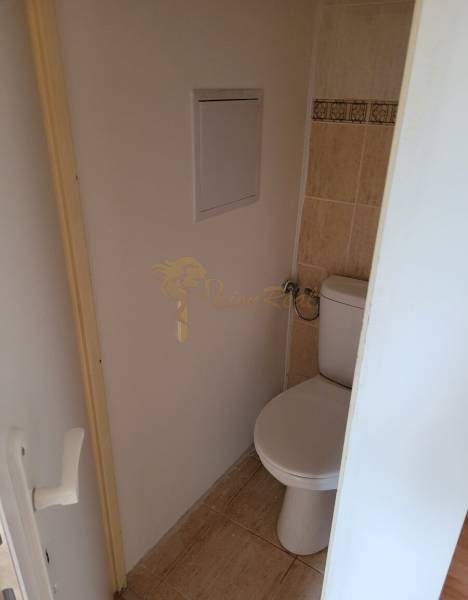 Toilette mit Fliesen und Eingangstüren in einer 3-Zimmer-Wohnung.