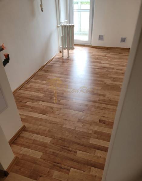 In einer 3-Zimmer-Wohnung ist ein Raum mit Holzboden und Heizkörper zu sehen.