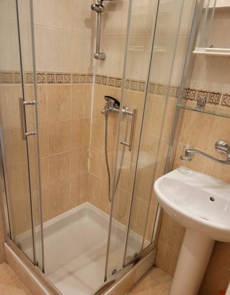 Duschkabine und Waschbecken im Badezimmer einer 3-Zimmer-Wohnung mit Glastüren.