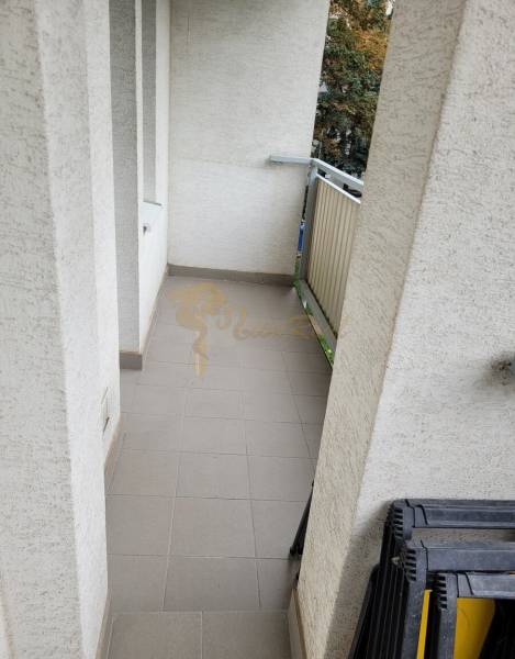 Ein schmaler Balkon in einer 3-Zimmer-Wohnung mit Geländer und Fliesen.