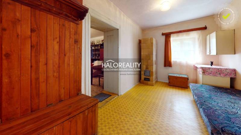 Ein Zimmer in einer Hütte mit einem Holzbett und einem Schminktisch, ein heller Raum mit einem großen Fenster.