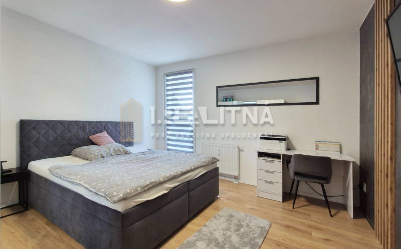 Schlafzimmer in einer 4-Zimmer-Wohnung mit Doppelbett, Schreibtisch und Fenster mit Rollladen.