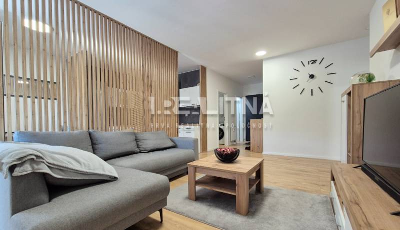 Ein stilvolles Wohnzimmer in einer 4-Zimmer-Wohnung mit Holzverkleidung, einem bequemen Sofa und einem Tisch.