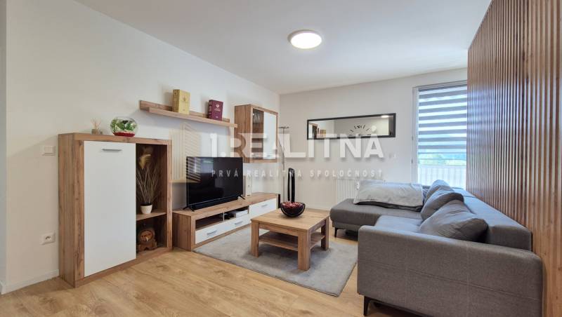 Wohnzimmer in einer 4-Zimmer-Wohnung mit einem bequemen Sofa und Holzmöbeln.