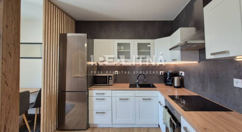 Küche mit Geräten und Holzelementen in einer 4-Zimmer-Wohnung.