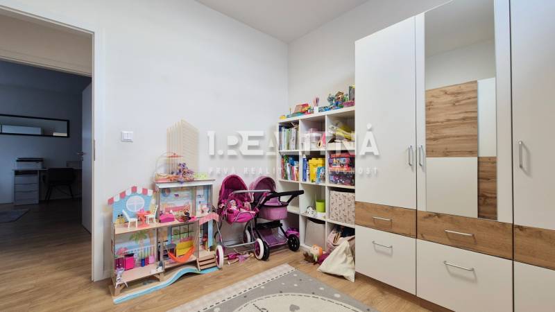 Kinderzimmer mit Spielzeug und Schrank in einer 4-Zimmer-Wohnung, heller Raum.
