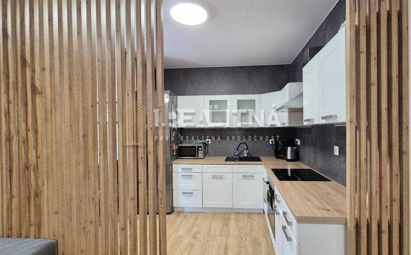 Küche mit hellen Möbeln in einer 4-Zimmer-Wohnung, Holzelemente, moderne Geräte.