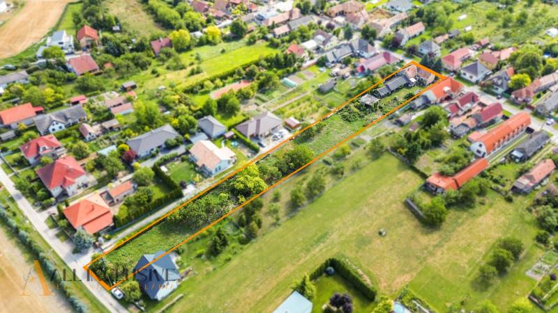 Luftaufnahme von Grundstücken - Wohnen in der Gemeinde Báč mit Umgebung und Gebäuden.