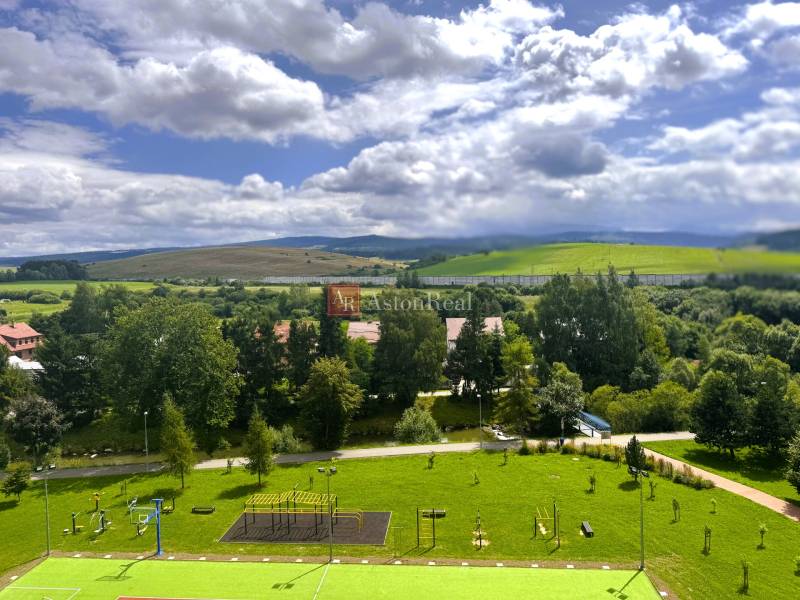 Blick aus einer 2-Zimmer-Wohnung im Westen von Tvrdošín, mit Spielplatz und hügeliger Landschaft.