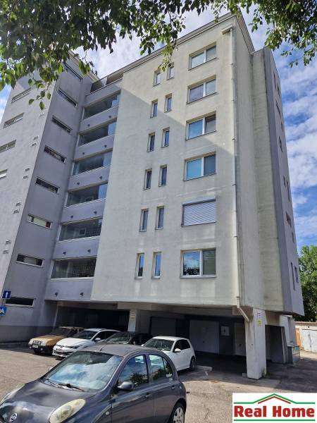 Wohngebäude an der Vrakunská-Straße in Bratislava - Ružinov mit einem Parkplatz vor dem Gebäude.