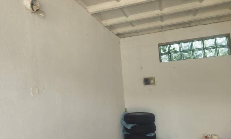 Weiße Wände, Reifen, Glühbirne, Schalter und kleines Fenster in der Garage.