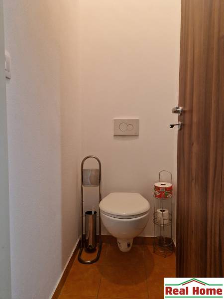 Badezimmer mit Toilette und Toilettenpapierhaltern in einer Einzimmerwohnung.