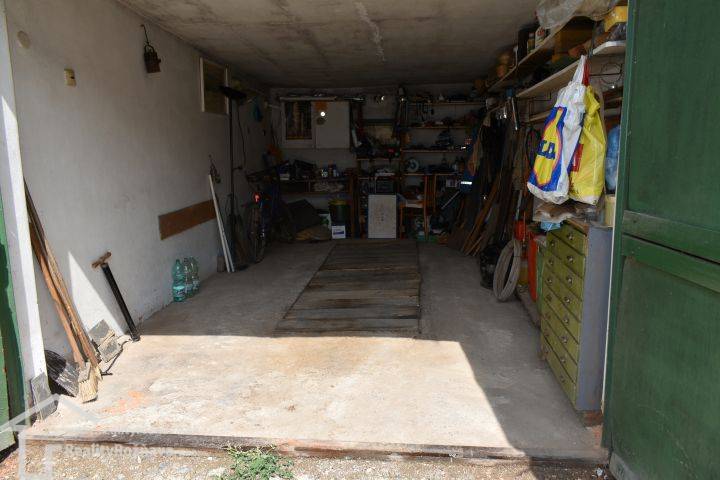 Garagen voller Werkzeuge und Ausrüstung, einschließlich Tisch, Regale und Fahrrad.