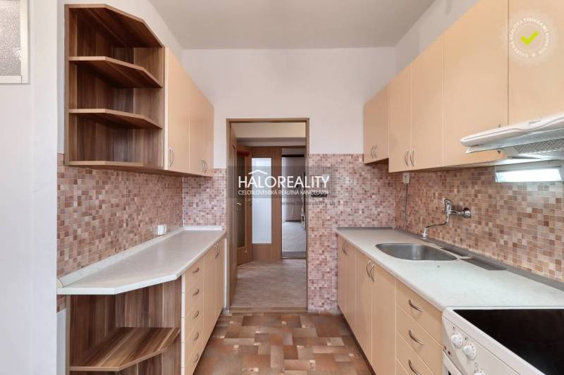 Küche in einer 3-Zimmer-Wohnung mit Holzschränken und Fliesenverkleidung.