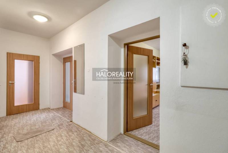 Flur einer 3-Zimmer-Wohnung mit Holztüren und Spiegel.
