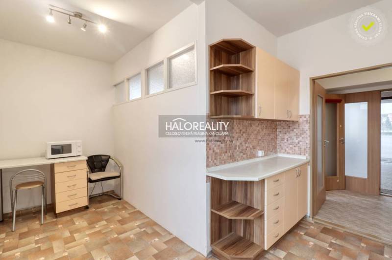 Küche in einer 3-Zimmer-Wohnung mit Mikrowelle, Stuhl und Schränken als Stauraum.