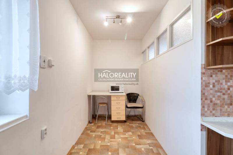 Gemütlicher Raum mit Mikrowelle und Fenster in einer 3-Zimmer-Wohnung.