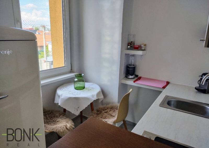 Küche in einer 2-Zimmer-Wohnung mit Fenster, Bartresen und Essecke.