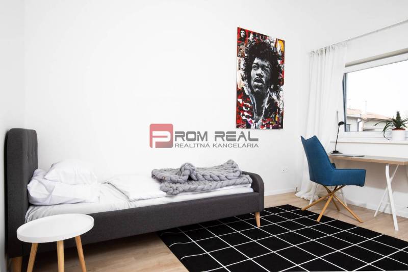 Schlafzimmer in einer 3-Zimmer-Wohnung mit Bett, Sessel und Bild an der Wand.