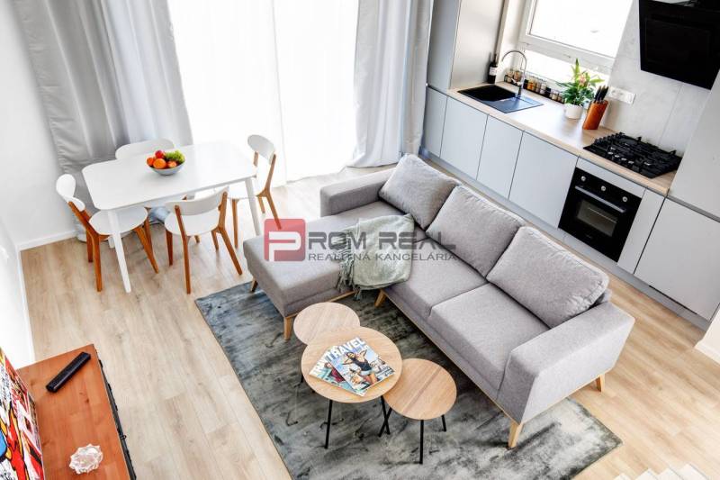 Küche und Wohnzimmer in einer 3-Zimmer-Wohnung mit Esstisch und Sofa.