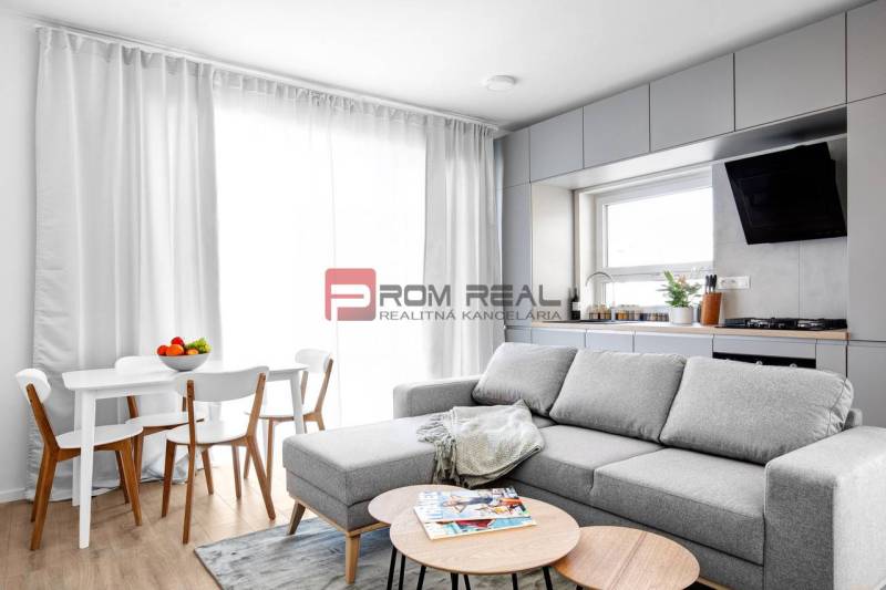 Wohnzimmer mit Küche in einer 3-Zimmer-Wohnung, helles Sofa und Esstisch.