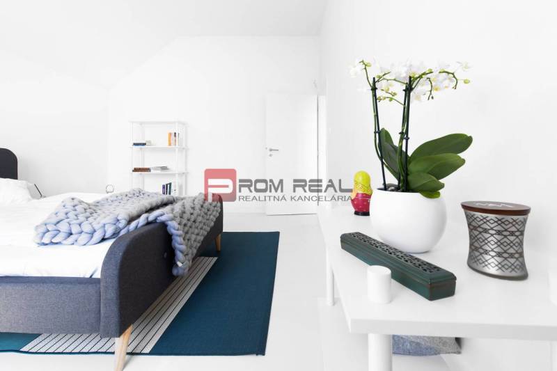 Schlafzimmer mit Bett, weißen Möbeln und Dekorationen in einer 3-Zimmer-Wohnung.
