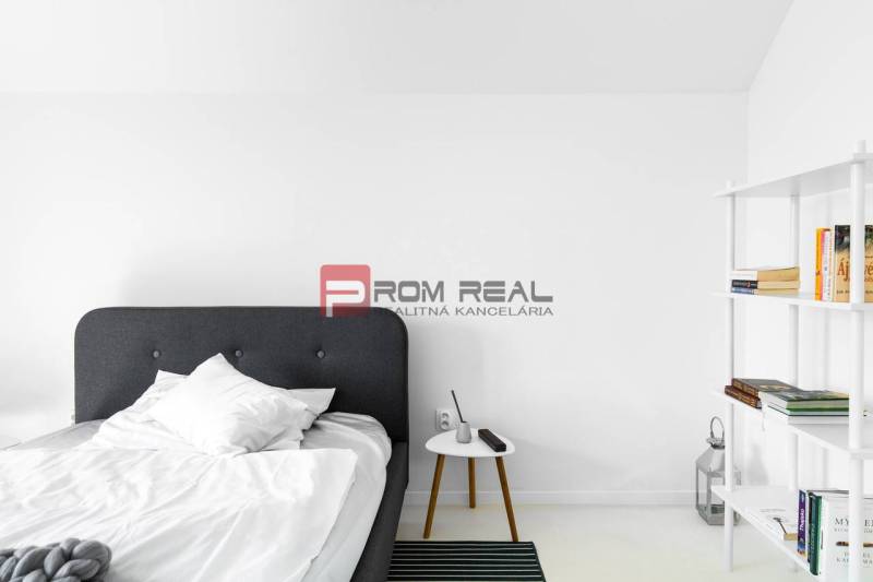Schlafzimmer mit Bett und Regal mit Büchern in einer 3-Zimmer-Wohnung.