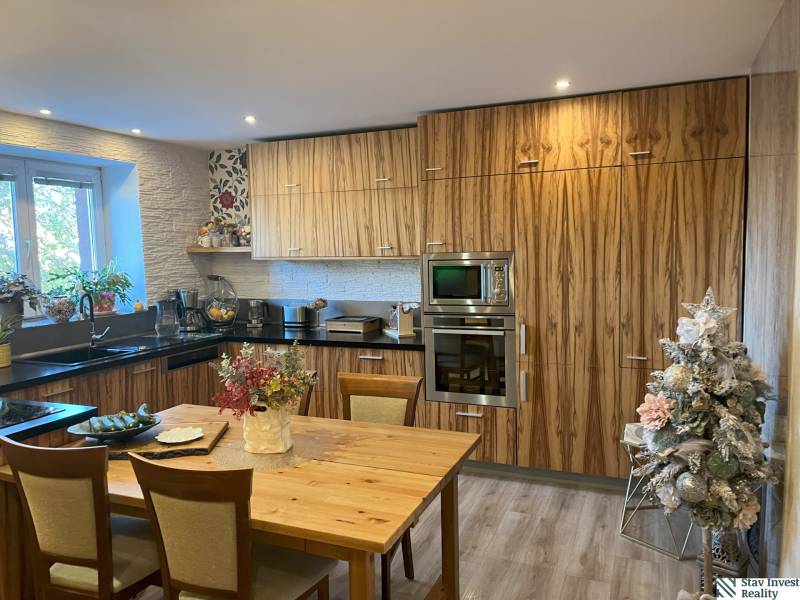 Küche in einer 2-Zimmer-Wohnung mit Holzschränken, Tisch und Weihnachtsdekoration.