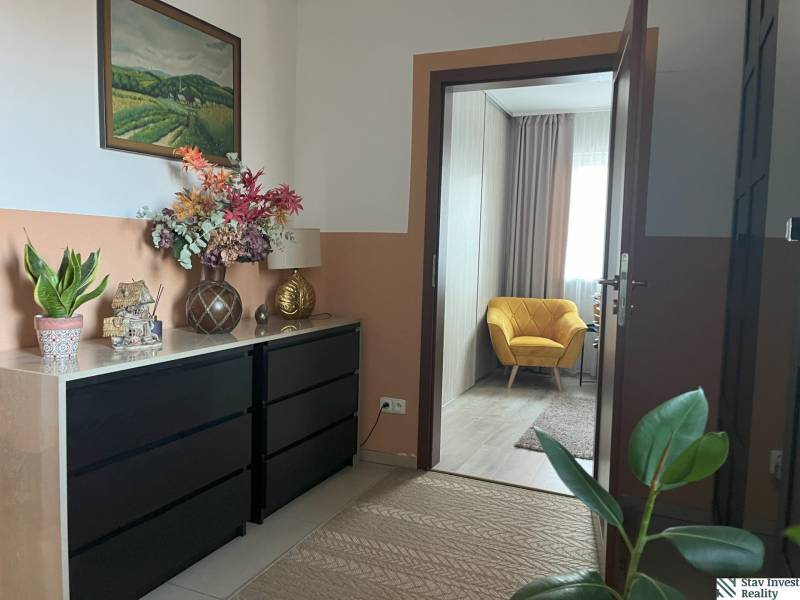 Im Flur der 2-Zimmer-Wohnung befinden sich ein Schrank, Dekorationen und ein gelber Sessel.
