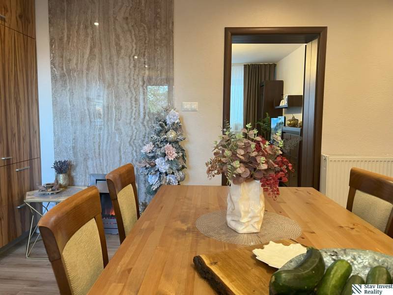 Esstisch mit Blumen, geschmückter Baum und Küche in einer 2-Zimmer-Wohnung.
