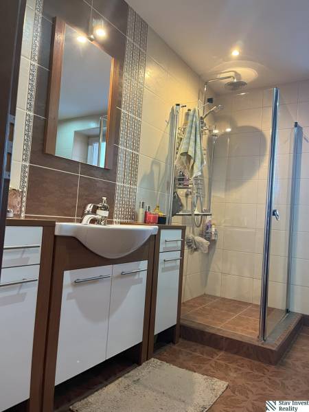Badezimmer einer 2-Zimmer-Wohnung mit Dusche, Waschbecken und Schränken.