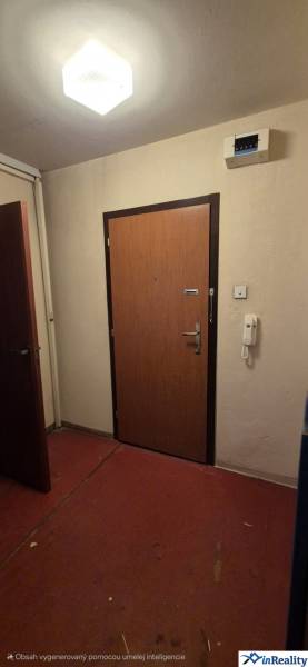 Eingangstür zu einer 3-Zimmer-Wohnung mit rotem Linoleum und weißen Wänden.