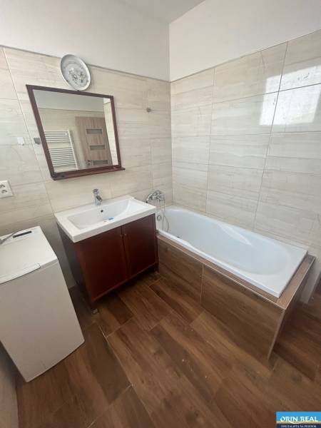 Badezimmer in einer 3-Zimmer-Wohnung mit Badewanne, Waschbecken und Waschmaschine.