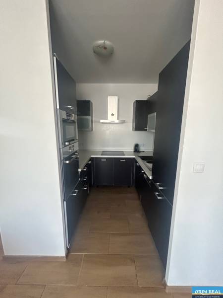 Küche in einer 3-Zimmer-Wohnung mit dunklen Schränken und eingebauten Geräten.